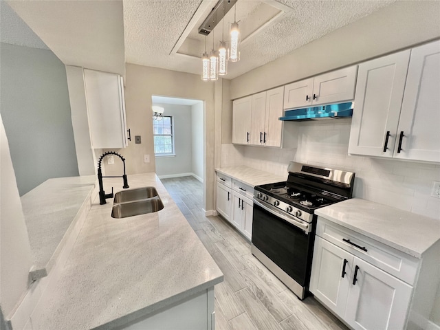 kitchen featuring white cabinetry, sink, and stainless steel stove