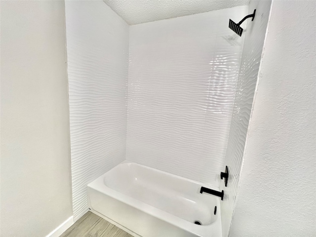 bathroom with shower / washtub combination, wood-type flooring, and a textured ceiling