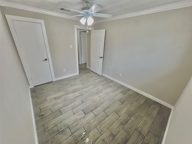 unfurnished bedroom featuring light hardwood / wood-style flooring, ceiling fan, and crown molding