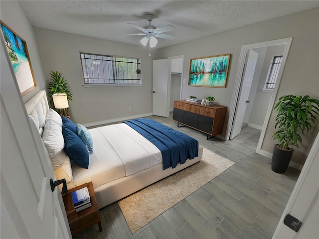 bedroom featuring a textured ceiling, light wood-type flooring, and ceiling fan