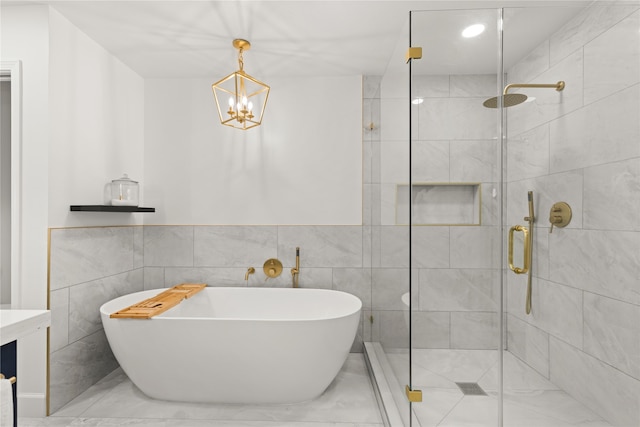 bathroom with vanity, tile walls, independent shower and bath, and a notable chandelier