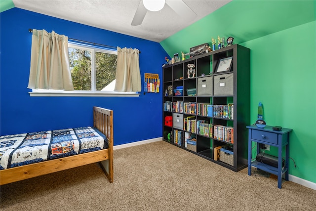 carpeted bedroom with a textured ceiling, vaulted ceiling, and ceiling fan