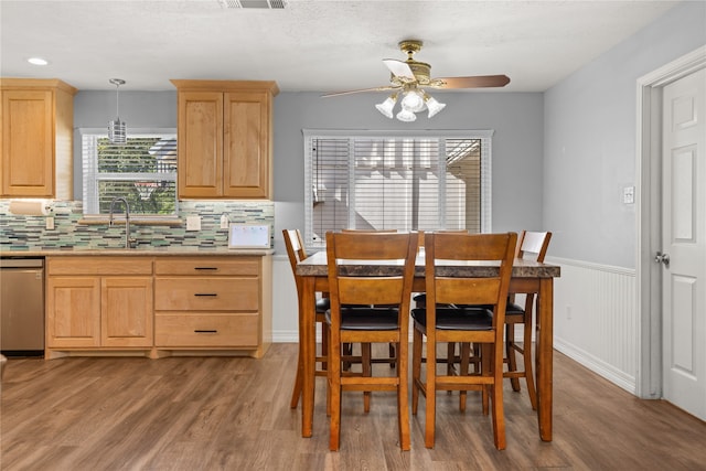 dining area featuring a textured ceiling, light hardwood / wood-style floors, ceiling fan, and sink