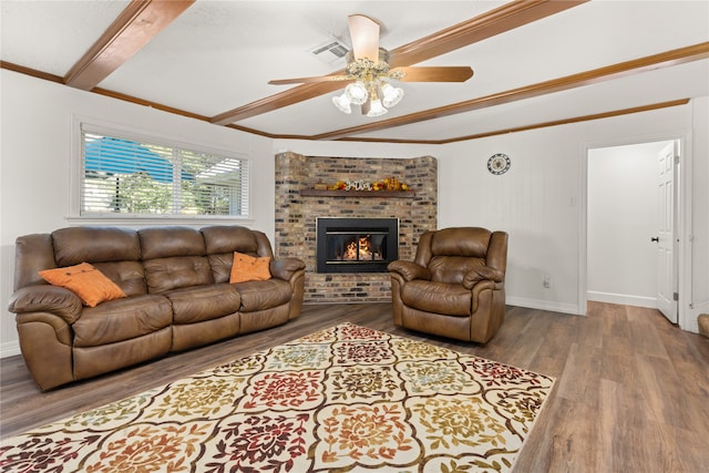 living room with crown molding, ceiling fan, a fireplace, beamed ceiling, and wood-type flooring