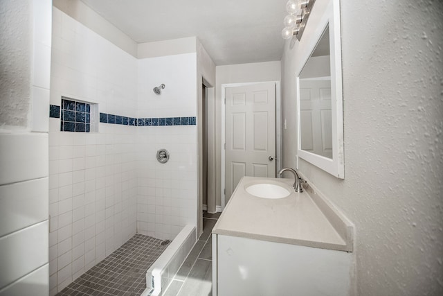 bathroom with vanity and tiled shower