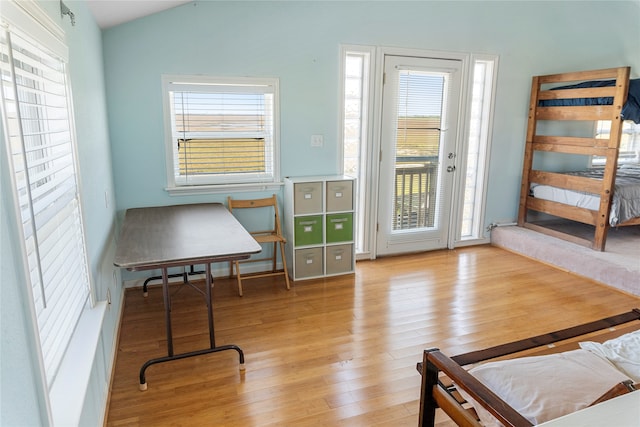 doorway to outside featuring lofted ceiling and light hardwood / wood-style flooring