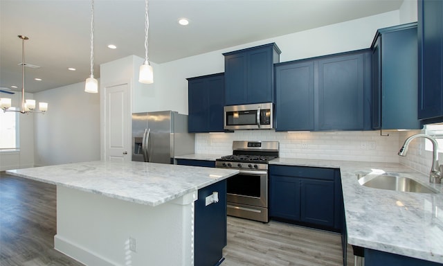 kitchen with sink, a kitchen island, stainless steel appliances, and light hardwood / wood-style floors