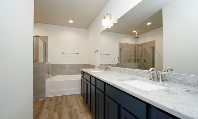 bathroom featuring hardwood / wood-style floors, vanity, and shower with separate bathtub