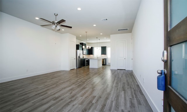 unfurnished living room with ceiling fan, dark wood-type flooring, and sink