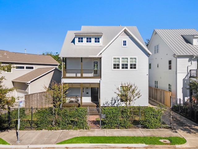 view of front of property featuring a fenced front yard and a balcony