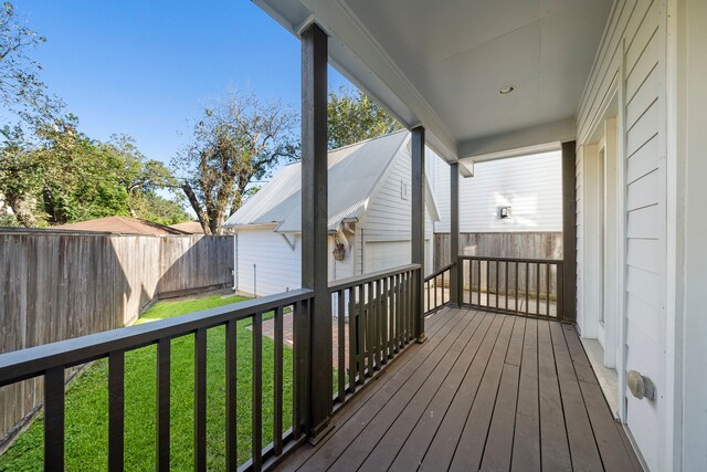 wooden terrace featuring a yard, an outbuilding, and a garage