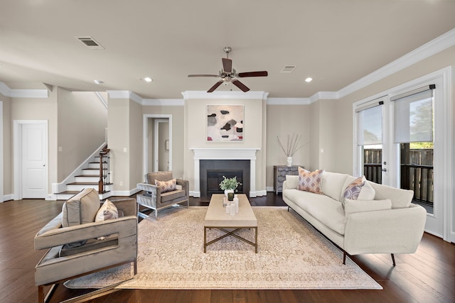 living room with dark hardwood / wood-style floors, ceiling fan, and crown molding