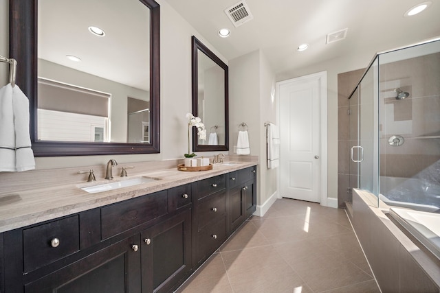 bathroom with tile patterned floors, vanity, and walk in shower