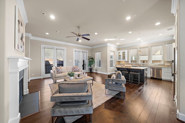 living room featuring ornamental molding, ceiling fan, and dark wood-type flooring