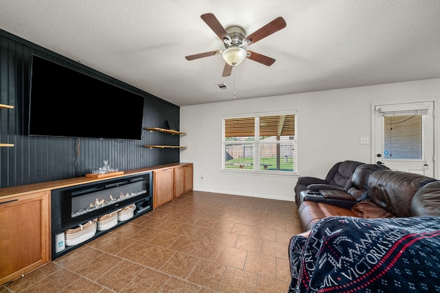 living room featuring indoor bar, a textured ceiling, ceiling fan, and wooden walls