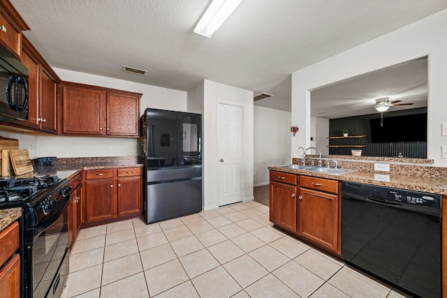 kitchen with dark stone counters, black appliances, sink, ceiling fan, and a textured ceiling