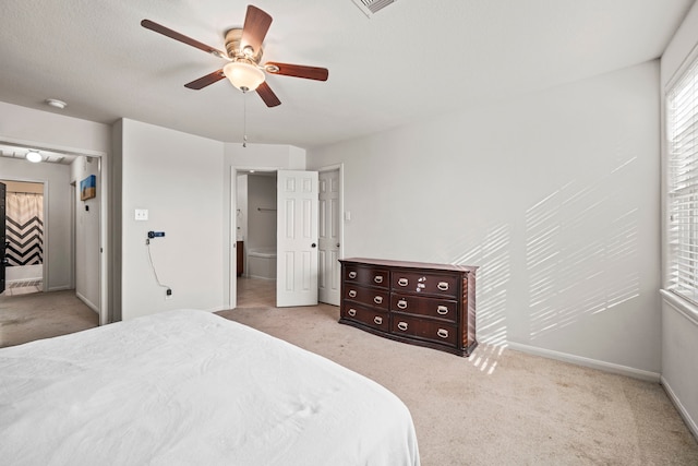 bedroom featuring connected bathroom, ceiling fan, and light colored carpet