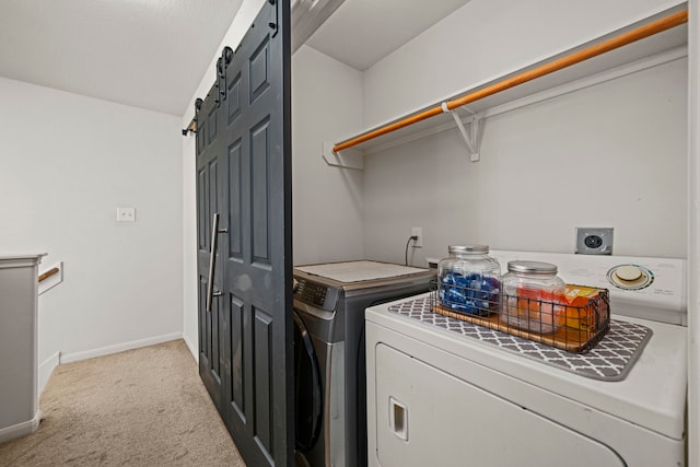 clothes washing area featuring a barn door, separate washer and dryer, and light carpet