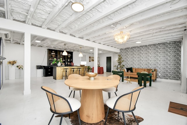 dining area featuring concrete floors and an inviting chandelier