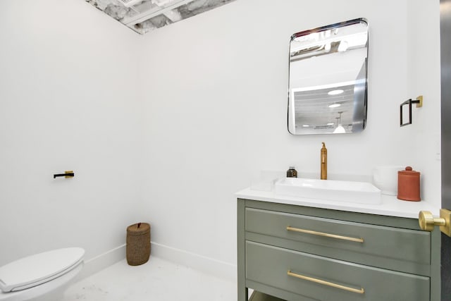 bathroom featuring concrete flooring, vanity, and toilet