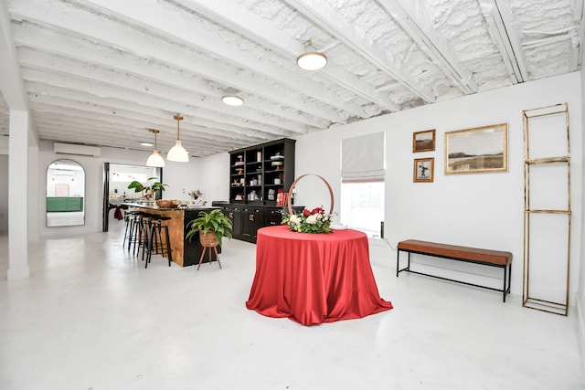 dining room with a wall mounted air conditioner and concrete floors