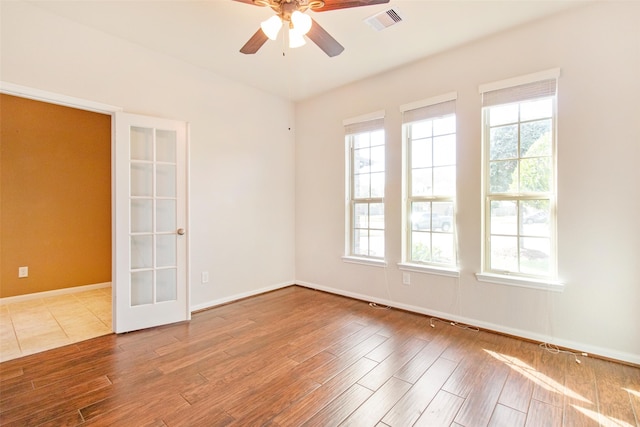 unfurnished room featuring ceiling fan, french doors, and hardwood / wood-style flooring