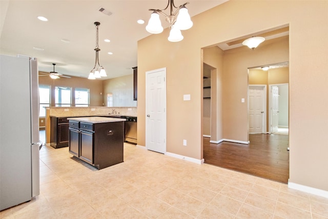 kitchen with ceiling fan with notable chandelier, a center island, hanging light fixtures, and appliances with stainless steel finishes