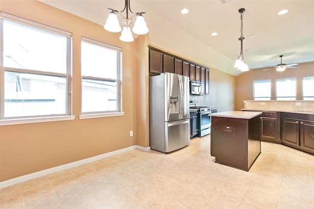 kitchen featuring appliances with stainless steel finishes, dark brown cabinetry, pendant lighting, a kitchen island, and lofted ceiling