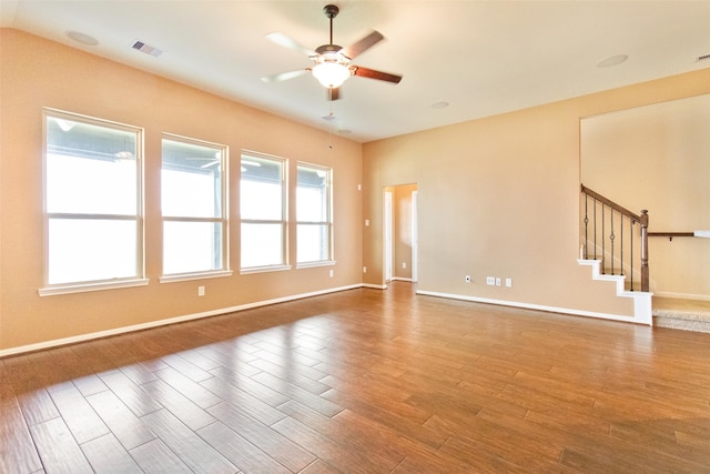 empty room with hardwood / wood-style flooring, ceiling fan, and a healthy amount of sunlight