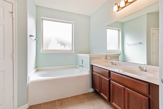 bathroom with tile patterned floors, a bathing tub, and vanity