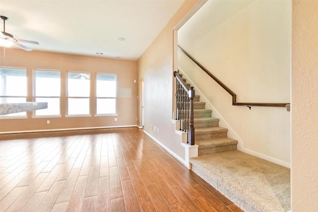 stairway featuring hardwood / wood-style flooring and ceiling fan