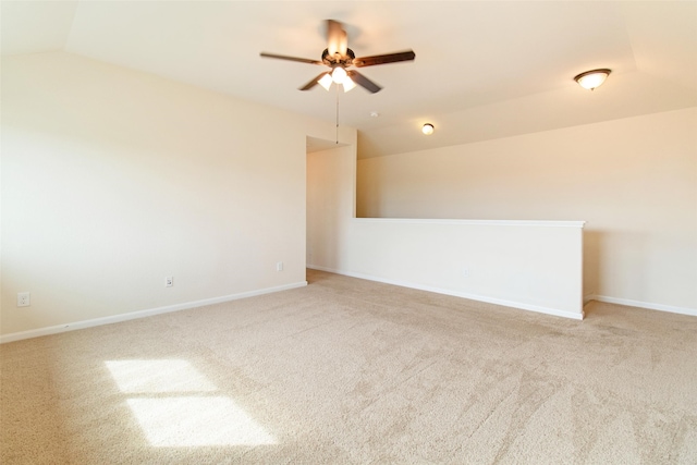 carpeted spare room with ceiling fan and vaulted ceiling