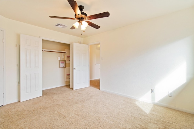 unfurnished bedroom with ceiling fan, light carpet, and a closet