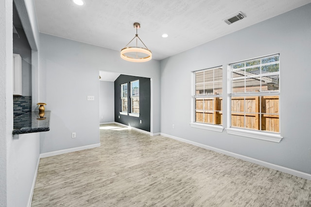 unfurnished dining area featuring hardwood / wood-style floors and plenty of natural light