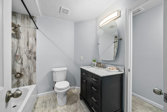 full bathroom with wood-type flooring, a textured ceiling, toilet, vanity, and tiled shower / bath