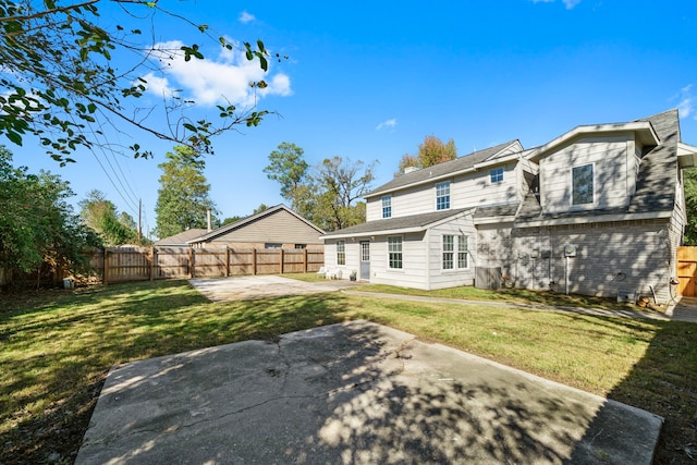 back of house with a patio area and a yard