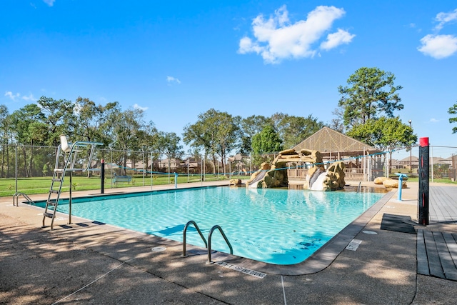 view of swimming pool with a patio area and a water slide