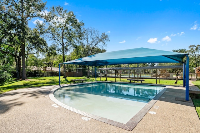 view of swimming pool featuring a yard