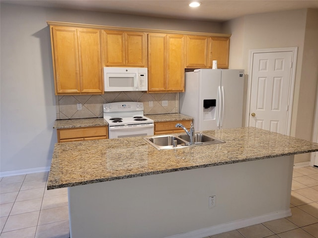 kitchen with sink, white appliances, light tile patterned flooring, and an island with sink