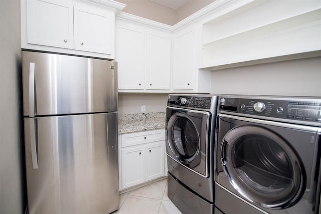 laundry room featuring washing machine and dryer and light tile patterned floors