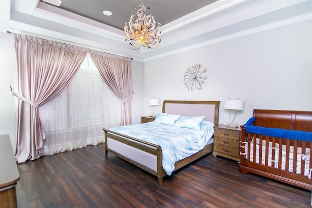 bedroom featuring a chandelier, a tray ceiling, dark hardwood / wood-style floors, and crown molding