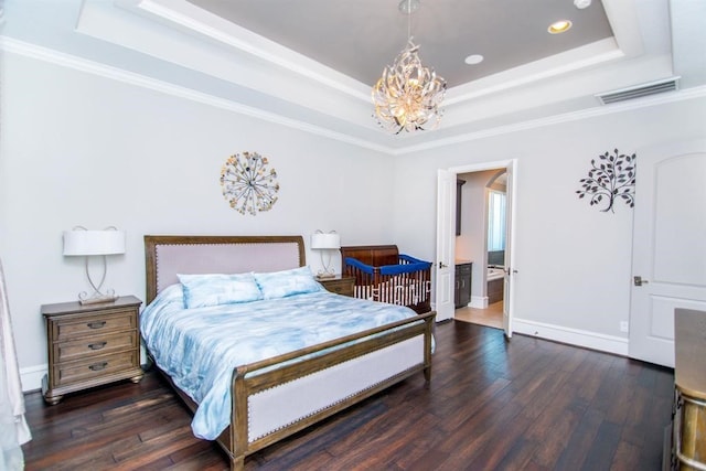 bedroom with connected bathroom, a raised ceiling, dark wood-type flooring, and crown molding