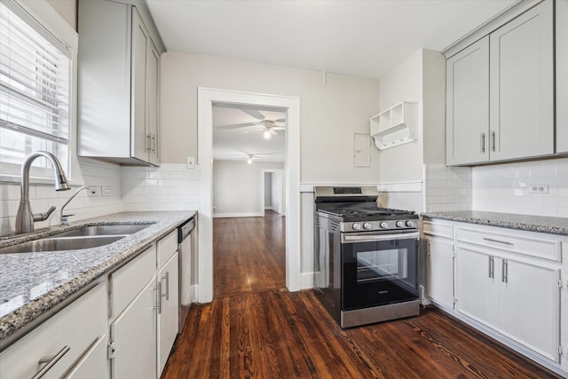 kitchen with sink, tasteful backsplash, appliances with stainless steel finishes, dark hardwood / wood-style floors, and light stone countertops