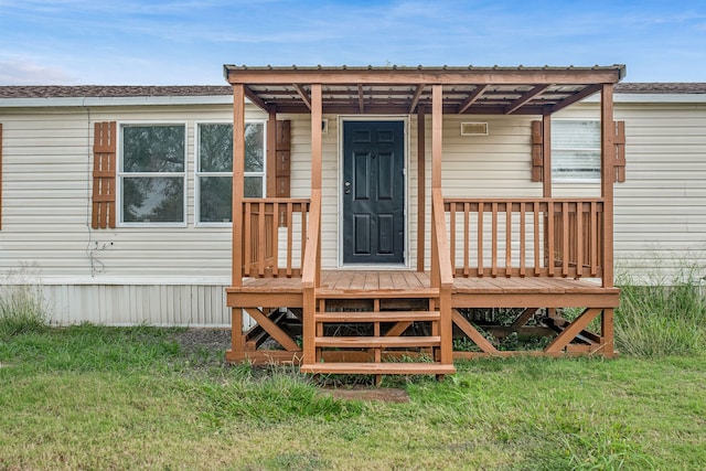 entrance to property featuring a lawn