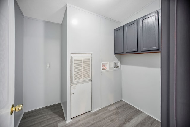 washroom featuring cabinets, hookup for a washing machine, light hardwood / wood-style floors, and ornamental molding