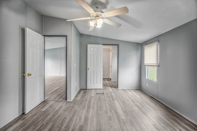 unfurnished bedroom with ceiling fan, light hardwood / wood-style floors, and lofted ceiling