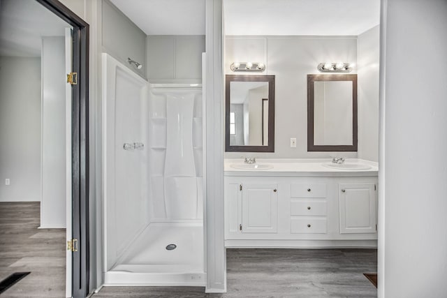 bathroom featuring vanity, a shower, and wood-type flooring