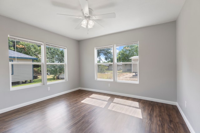 empty room with dark hardwood / wood-style flooring and ceiling fan