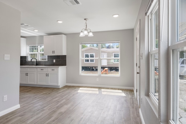 kitchen featuring white cabinets, plenty of natural light, and light hardwood / wood-style floors