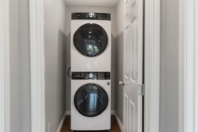 washroom with dark hardwood / wood-style flooring and stacked washer and clothes dryer